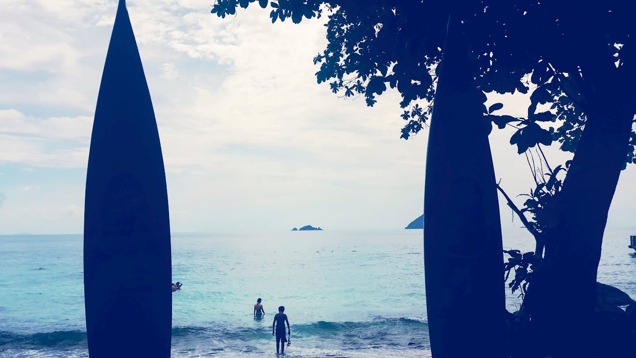Tranquil beach view with surfboards and ocean horizon in Terengganu, Malaysia.
